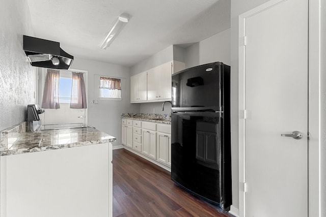 kitchen with sink, black refrigerator, white cabinets, and dark hardwood / wood-style floors