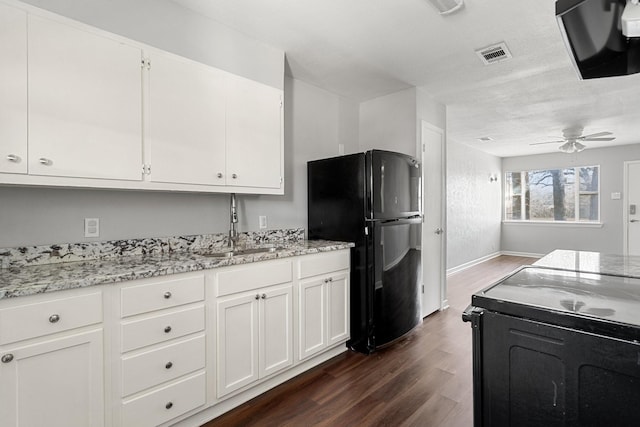 kitchen with white cabinetry, dark hardwood / wood-style floors, light stone countertops, and black appliances