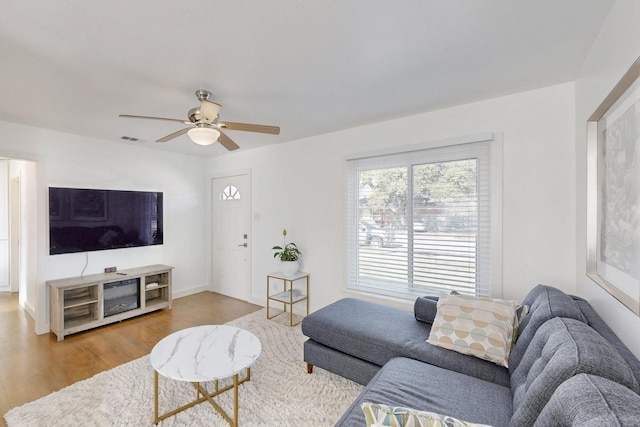 living room featuring hardwood / wood-style floors and ceiling fan