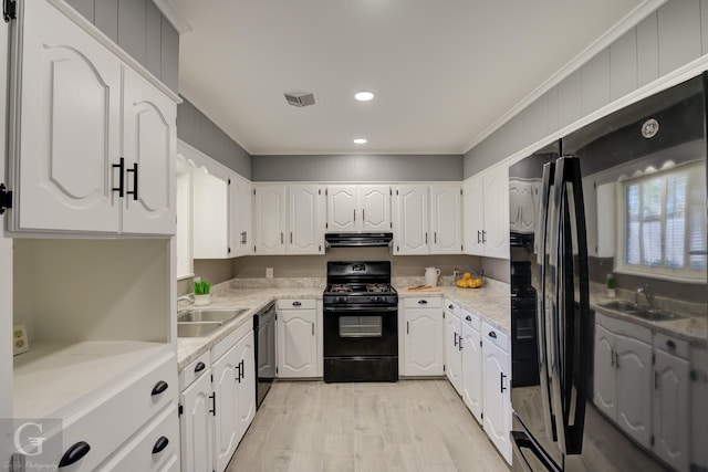 kitchen featuring sink, black appliances, and white cabinets