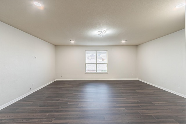 unfurnished room with dark hardwood / wood-style floors and a textured ceiling