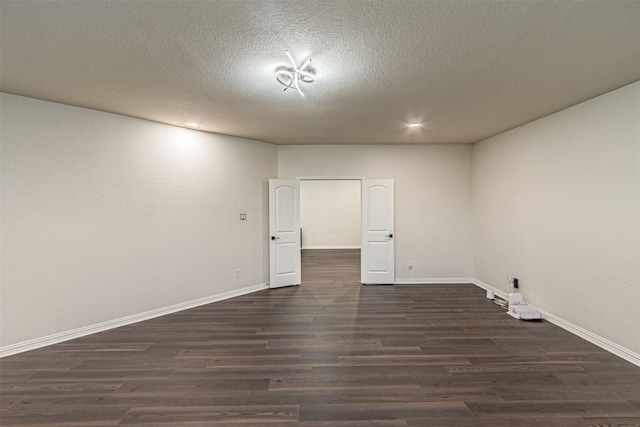 unfurnished room featuring a textured ceiling and dark hardwood / wood-style floors