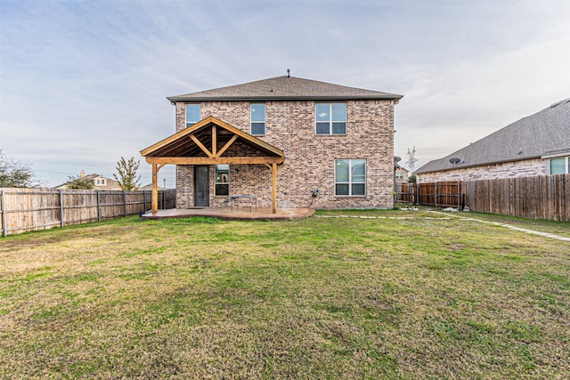 rear view of property with a yard and a patio area