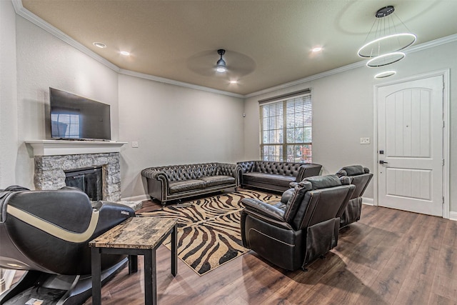 living room with a fireplace, ornamental molding, ceiling fan, and wood-type flooring