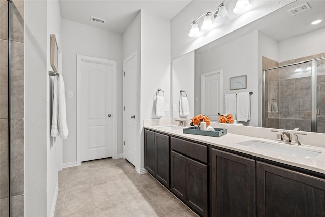 bathroom featuring vanity, tile patterned flooring, and a shower with shower door