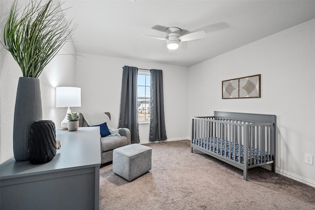 bedroom featuring a crib, ceiling fan, and carpet flooring