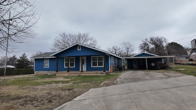 bungalow-style home featuring covered porch and a carport