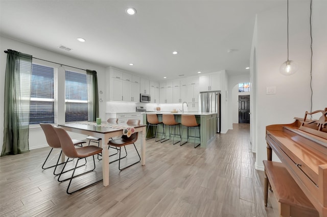 dining space featuring recessed lighting, visible vents, light wood-style flooring, and baseboards