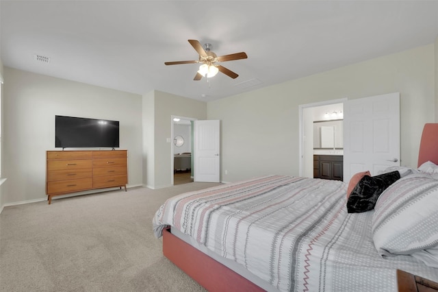 bedroom featuring visible vents, light carpet, baseboards, and ensuite bathroom