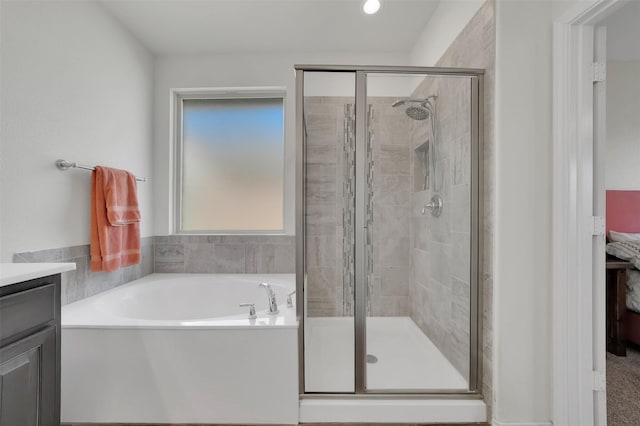 bathroom featuring a stall shower, a garden tub, and vanity