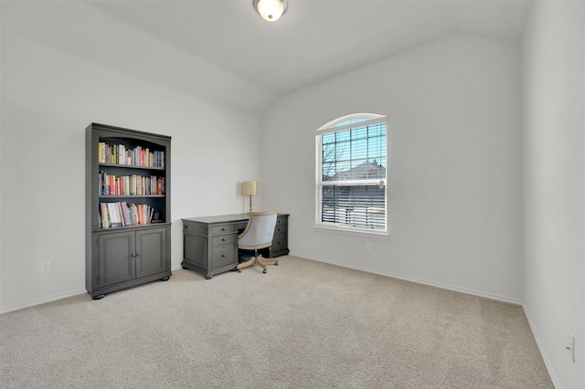 office space featuring vaulted ceiling, light carpet, and baseboards