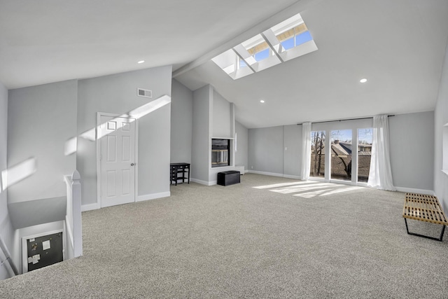 unfurnished living room featuring light carpet, vaulted ceiling with skylight, and a fireplace