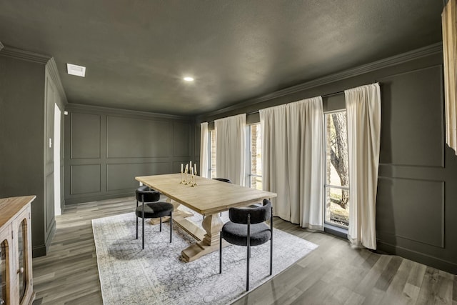 dining room featuring hardwood / wood-style flooring and crown molding