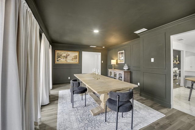 dining space with ornamental molding and hardwood / wood-style floors