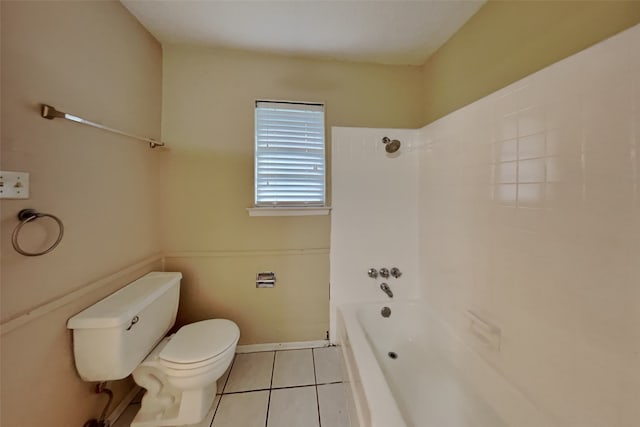 bathroom with tile patterned floors, toilet, and tiled shower / bath