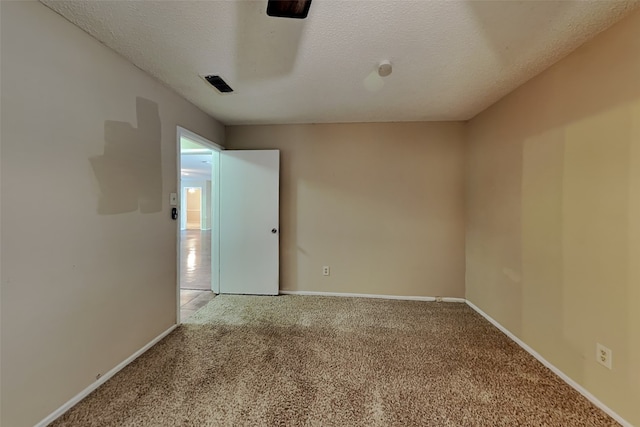 carpeted spare room with a textured ceiling