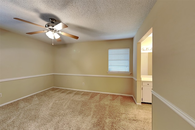 unfurnished room with light carpet, ceiling fan, and a textured ceiling