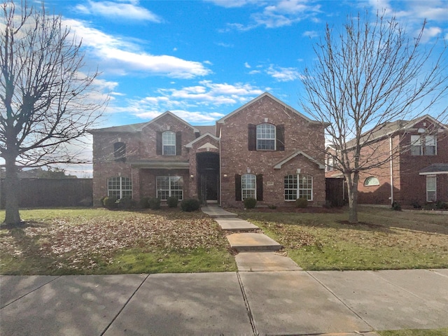 traditional-style home with brick siding and a front lawn