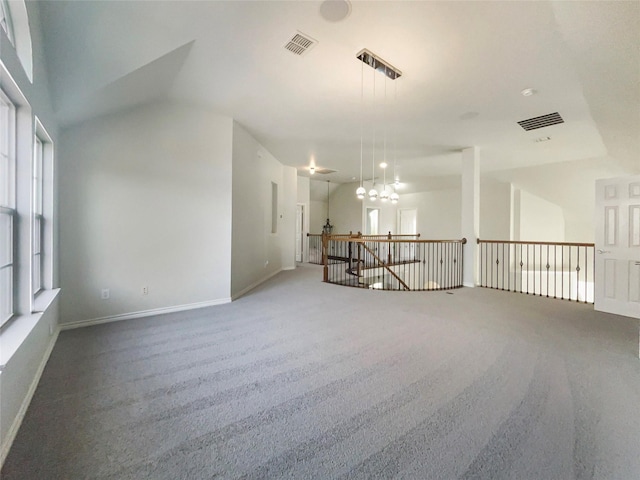 carpeted empty room with a notable chandelier