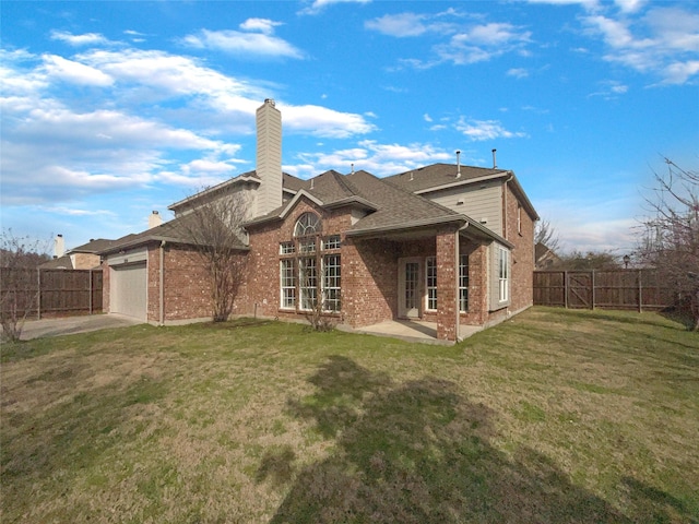 rear view of property with a garage and a yard