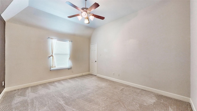 carpeted spare room with ceiling fan and vaulted ceiling