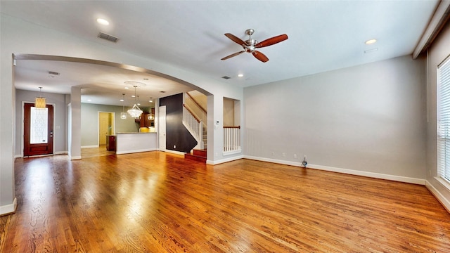 unfurnished living room with hardwood / wood-style flooring and ceiling fan with notable chandelier