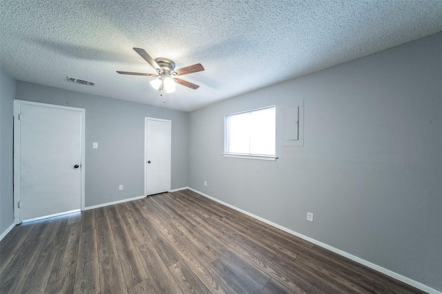 empty room featuring a textured ceiling, dark wood-type flooring, and ceiling fan