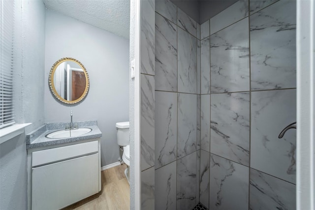 bathroom with vanity, walk in shower, a textured ceiling, toilet, and hardwood / wood-style flooring
