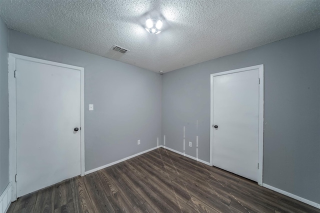 spare room with dark hardwood / wood-style flooring and a textured ceiling