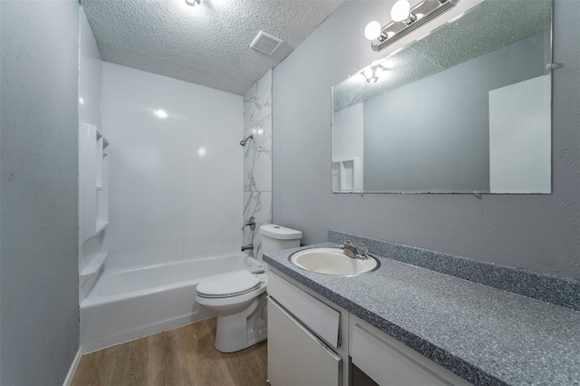 full bathroom featuring toilet,  shower combination, a textured ceiling, hardwood / wood-style floors, and vanity