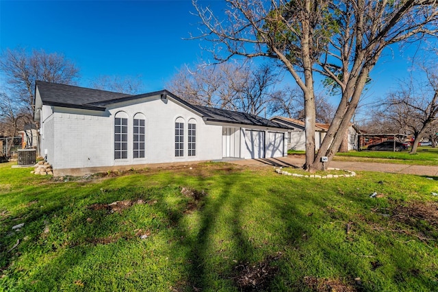 view of property exterior with central AC and a yard