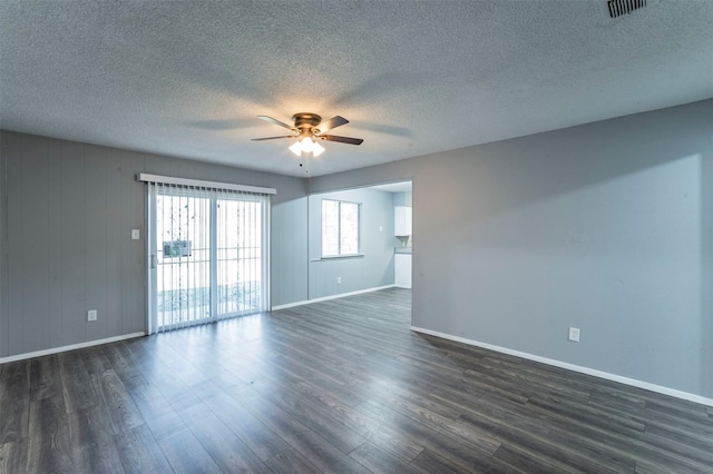 unfurnished room featuring a textured ceiling, dark wood-type flooring, and ceiling fan
