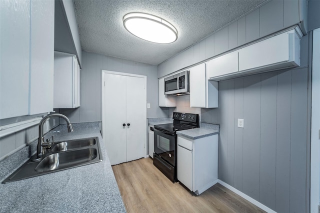 kitchen featuring light wood-type flooring, electric range, sink, a textured ceiling, and white cabinets
