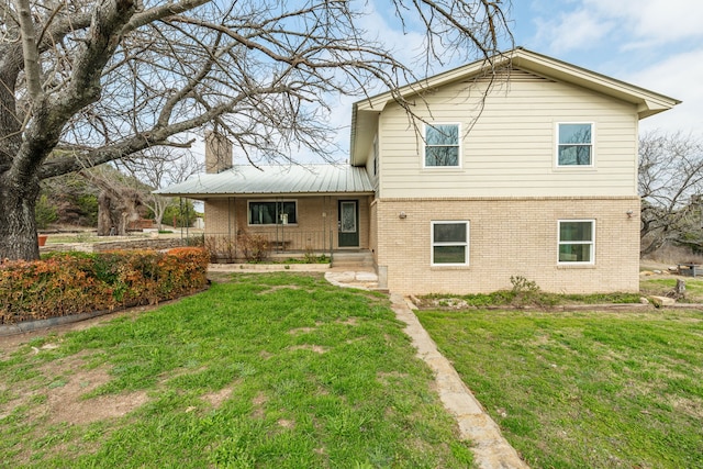 rear view of property featuring a lawn