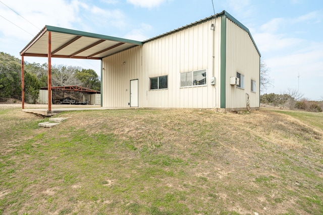 view of outbuilding with a lawn and a carport