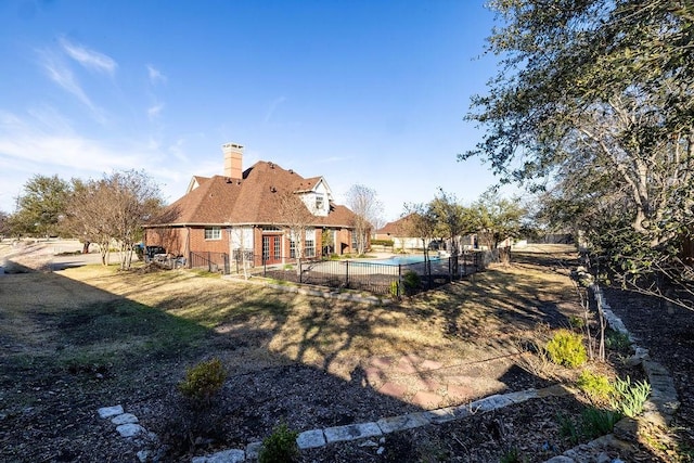 back of property with fence and a fenced in pool