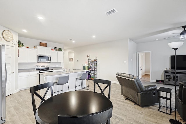 dining area featuring baseboards, visible vents, ceiling fan, light wood-style floors, and recessed lighting