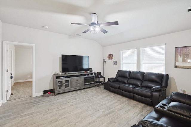 living room with ceiling fan, visible vents, baseboards, vaulted ceiling, and light wood finished floors