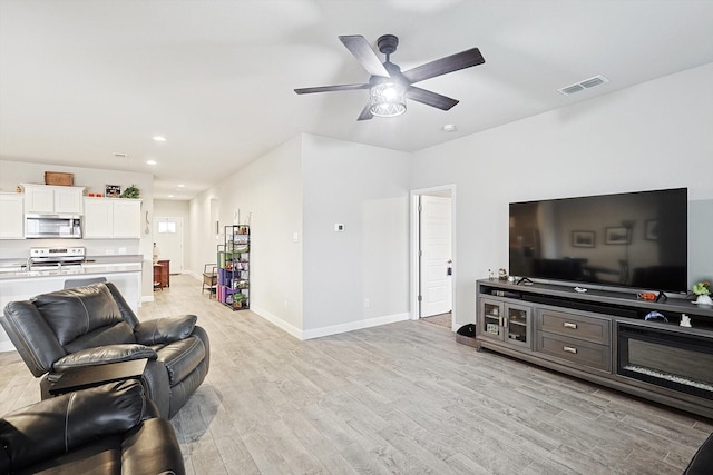 living room featuring light wood finished floors, recessed lighting, visible vents, a ceiling fan, and baseboards