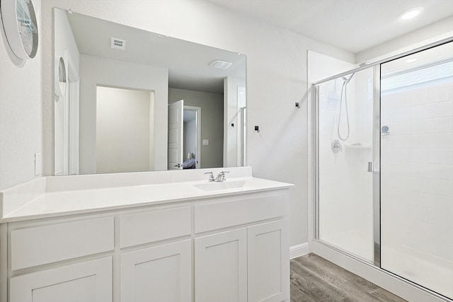 full bathroom with a stall shower, visible vents, connected bathroom, and wood finished floors