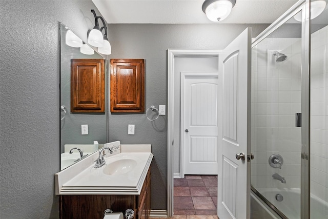 7621 Glenwood Springs Ln, Mckinney, TX 75070 - full bathroom featuring vanity, combined bath / shower with glass door, a textured wall, and tile patterned flooring