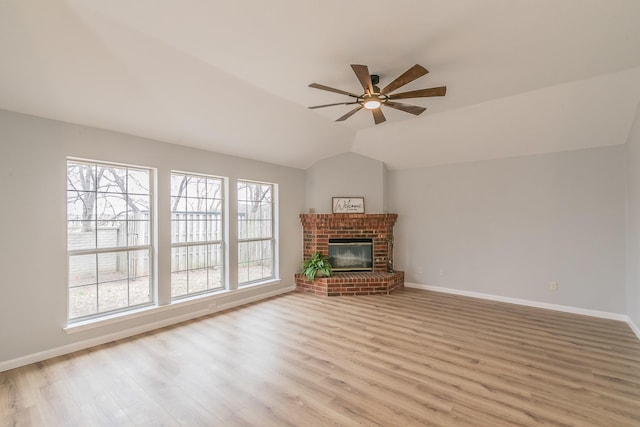 unfurnished living room featuring ceiling fan, light hardwood / wood-style floors, a brick fireplace, and lofted ceiling