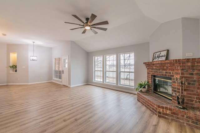 living room featuring ceiling fan, light hardwood / wood-style flooring, a brick fireplace, and lofted ceiling