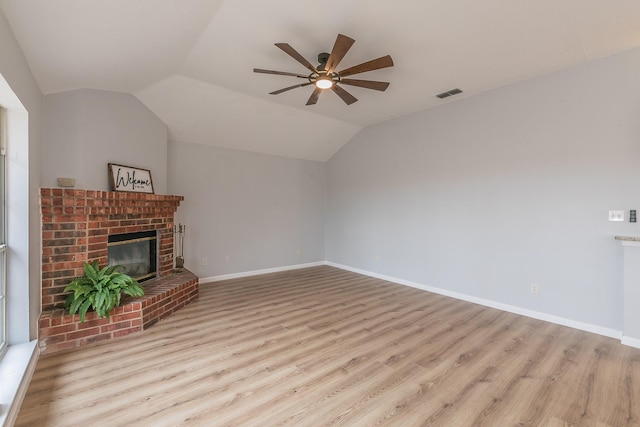 unfurnished living room featuring a fireplace, vaulted ceiling, ceiling fan, and light hardwood / wood-style flooring