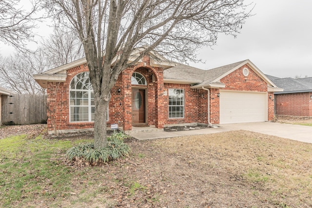 view of front of house with driveway, a shingled roof, an attached garage, fence, and brick siding