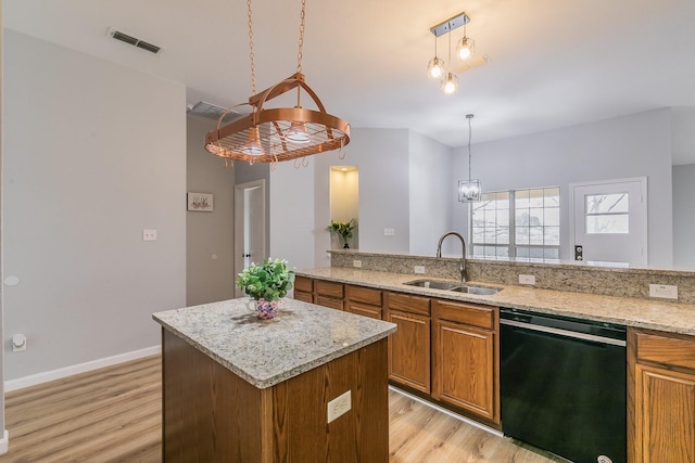 kitchen featuring light hardwood / wood-style flooring, hanging light fixtures, dishwasher, a center island, and sink