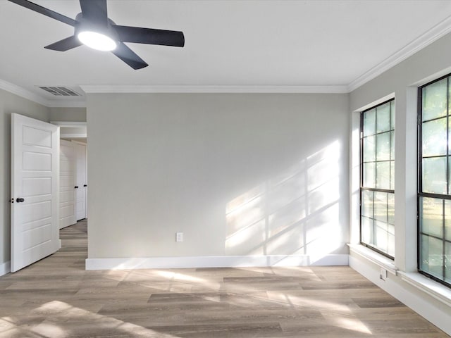 unfurnished room with ornamental molding, plenty of natural light, and light hardwood / wood-style flooring