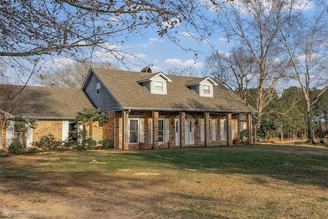 cape cod home with covered porch and a front yard