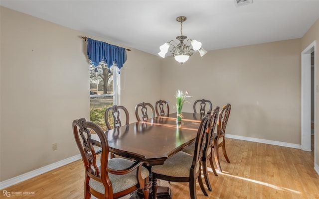 dining area featuring a notable chandelier and light hardwood / wood-style floors