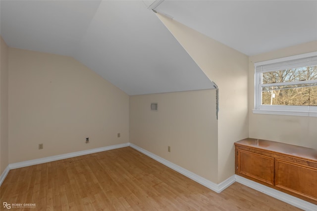 additional living space with lofted ceiling and light hardwood / wood-style floors